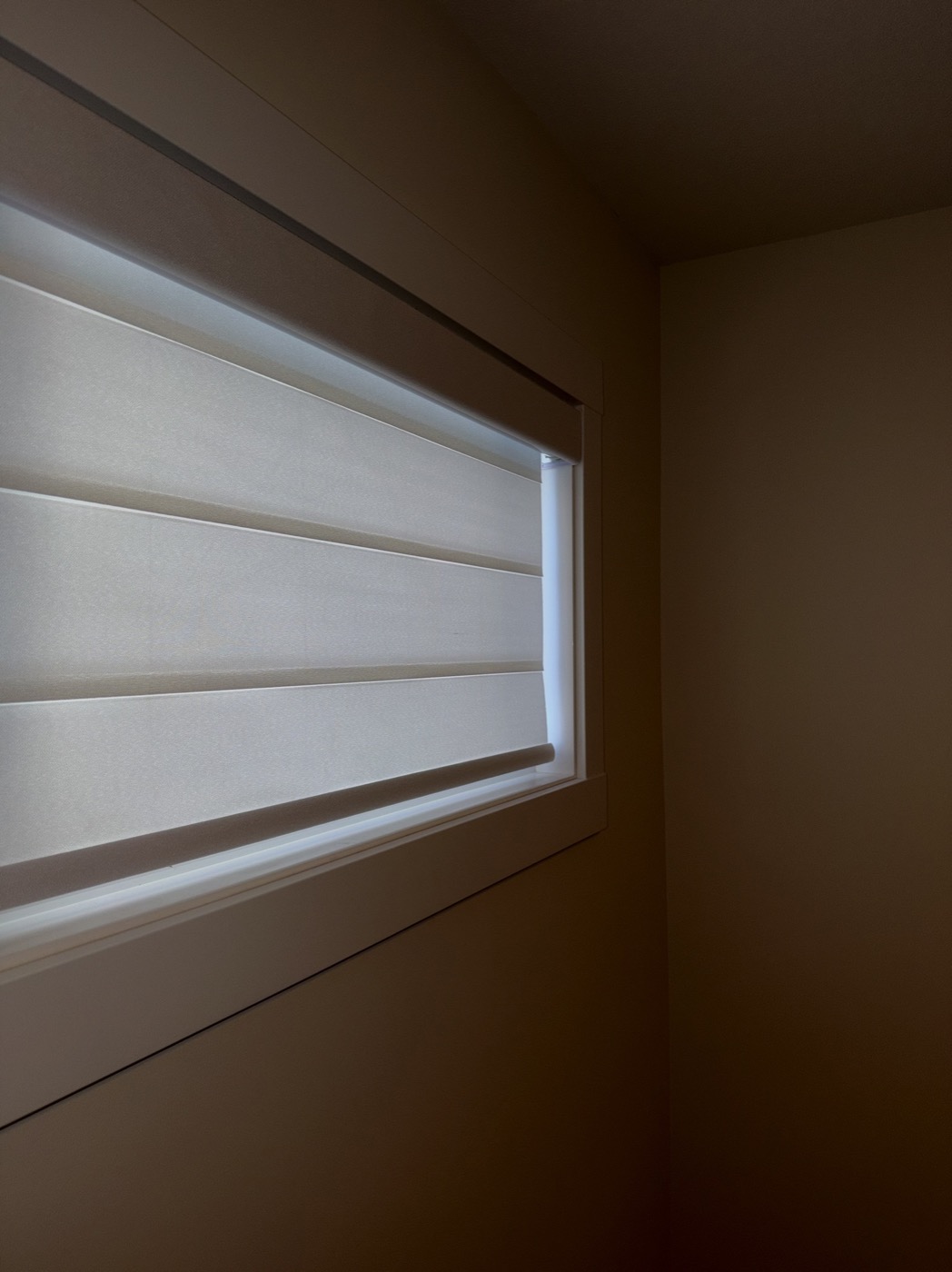 Close detail of a soft fabric shade installed inside a window frame